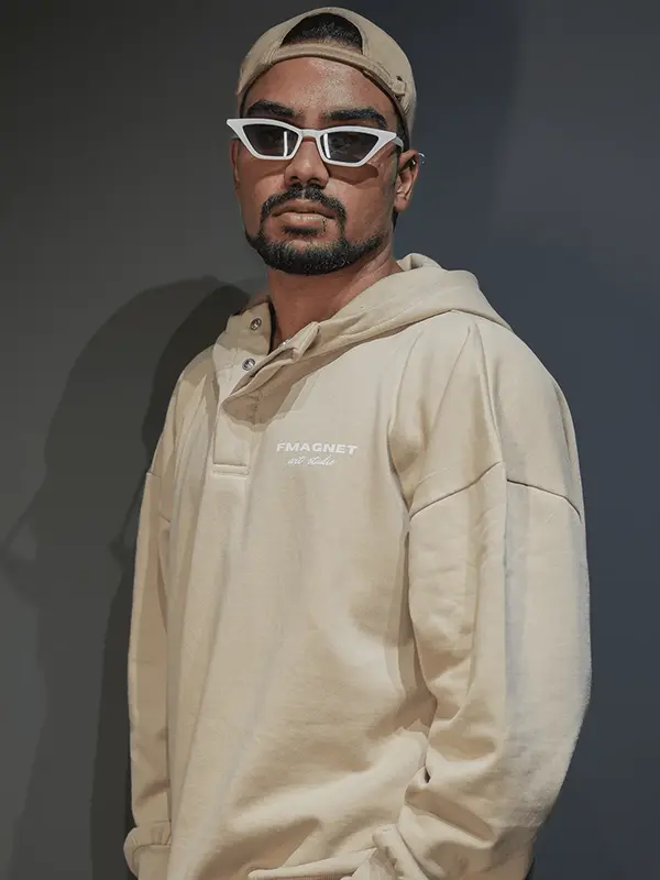 A male model posing wearing beige color unisex hoodie.